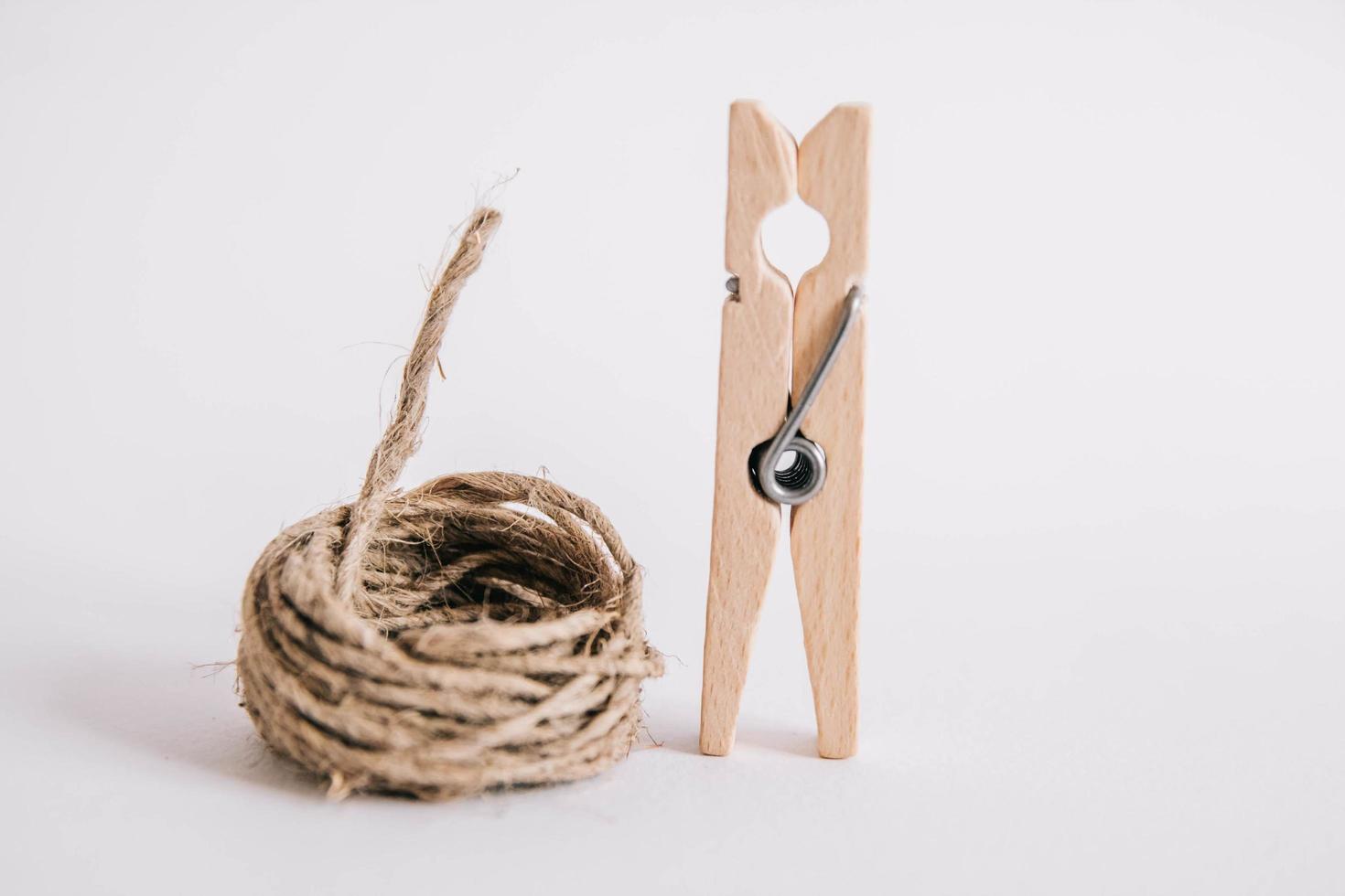 pince à linge en bois avec corde sur fond blanc. place pour votre texte photo