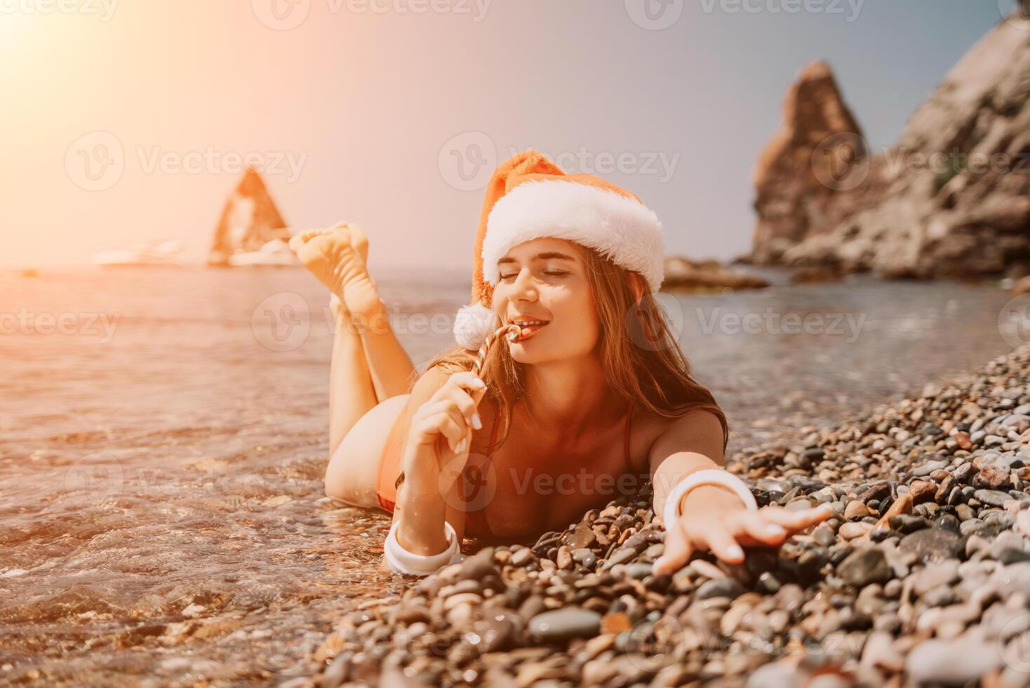 femme Voyage mer. content touristique prendre plaisir prise image sur le plage pour souvenirs. femme voyageur dans Père Noël chapeau regards à caméra sur le mer baie, partage Voyage aventure périple photo