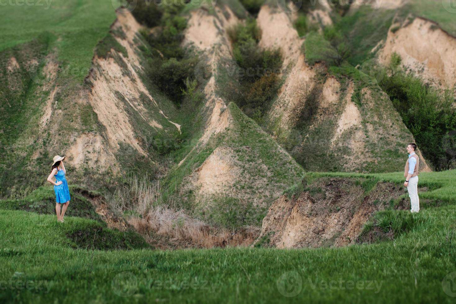 jeune couple, un gars et une fille marchent dans les collines de la montagne photo