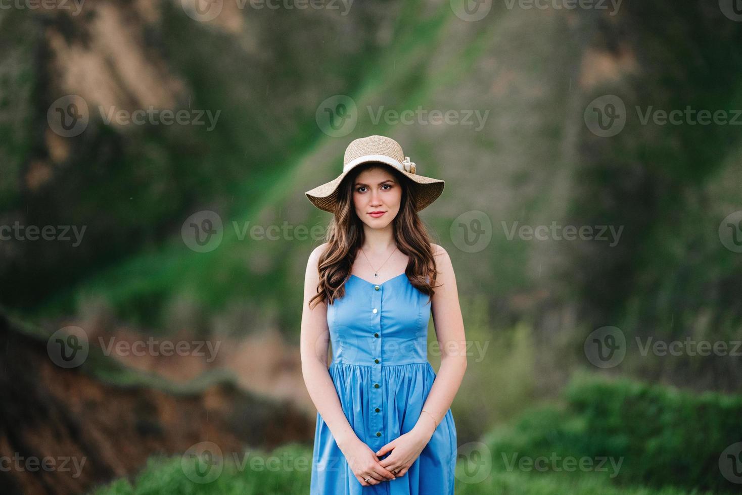 Jeune fille au chapeau de paille à large bord sur les pentes des montagnes photo