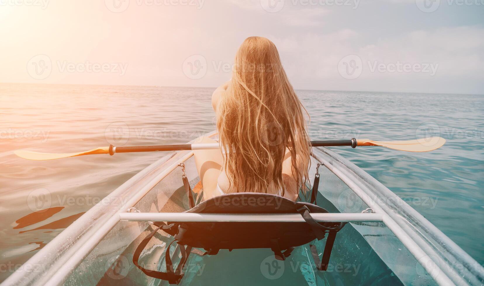 femme dans kayak retour voir. content Jeune femme avec longue cheveux flottant dans transparent kayak sur le cristal clair mer. été vacances vacances et de bonne humeur femelle gens relaxant ayant amusement sur le bateau photo