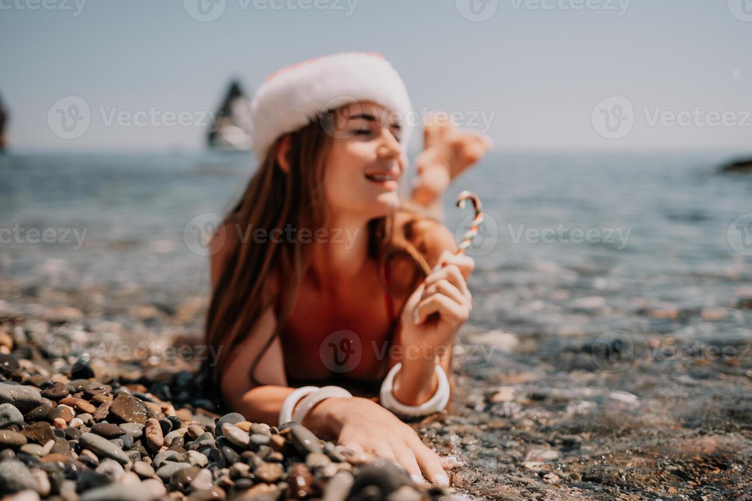 femme Voyage mer. content touristique prendre plaisir prise image sur le plage pour souvenirs. femme voyageur dans Père Noël chapeau regards à caméra sur le mer baie, partage Voyage aventure périple photo