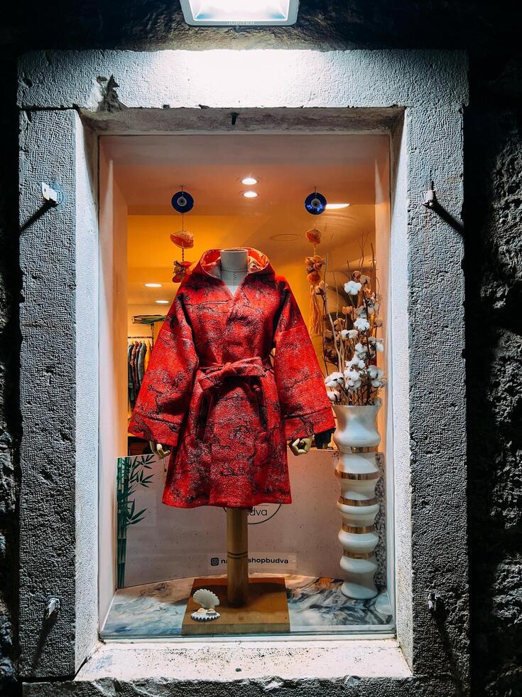 boudva, Monténégro - 25 décembre 2022. brillant rouge femmes manteau dans une magasin fenêtre photo