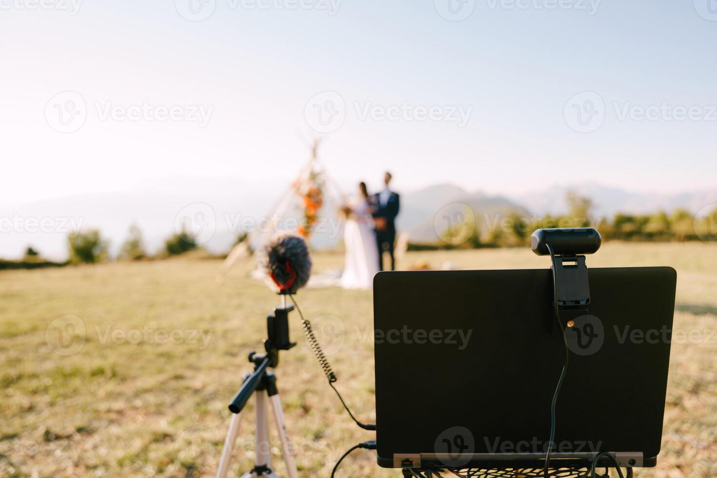 portable avec une webcam et une microphone des stands contre le Contexte de le la mariée et jeune marié près le mariage cambre photo