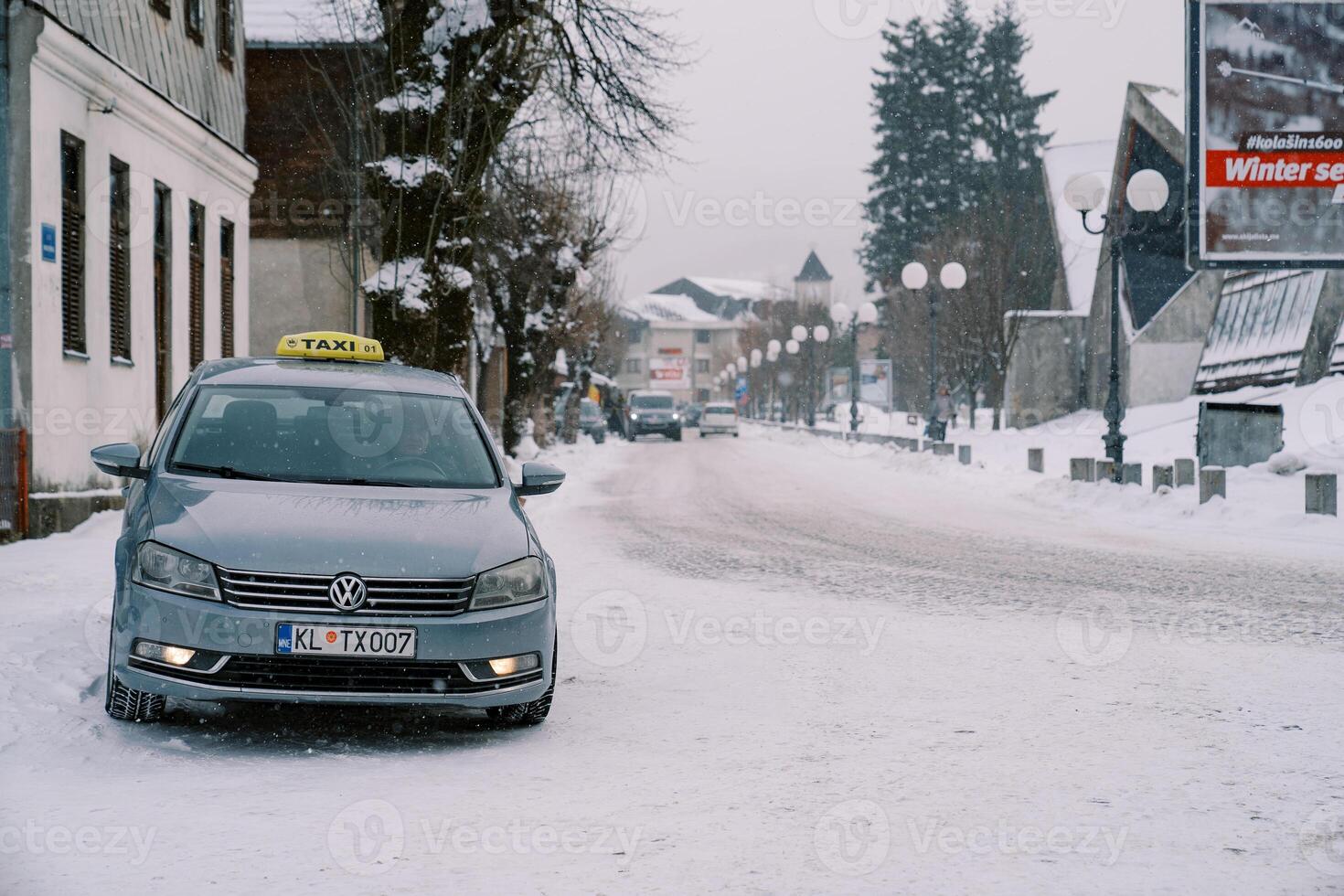 Taxi garé sur le côté de une neigeux route près une bâtiment photo