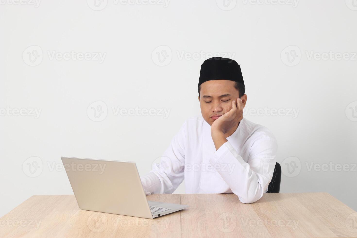 portrait de fatigué asiatique musulman homme dans koko chemise avec calotte travail pendant jeûne sur Ramadan mois, sentiment somnolent, bâillement avec main couvrant bouche. isolé image sur blanc Contexte photo