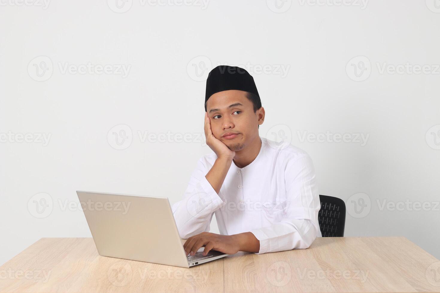 portrait de fatigué asiatique musulman homme dans koko chemise avec calotte travail pendant jeûne sur Ramadan mois, sentiment somnolent, bâillement avec main couvrant bouche. isolé image sur blanc Contexte photo