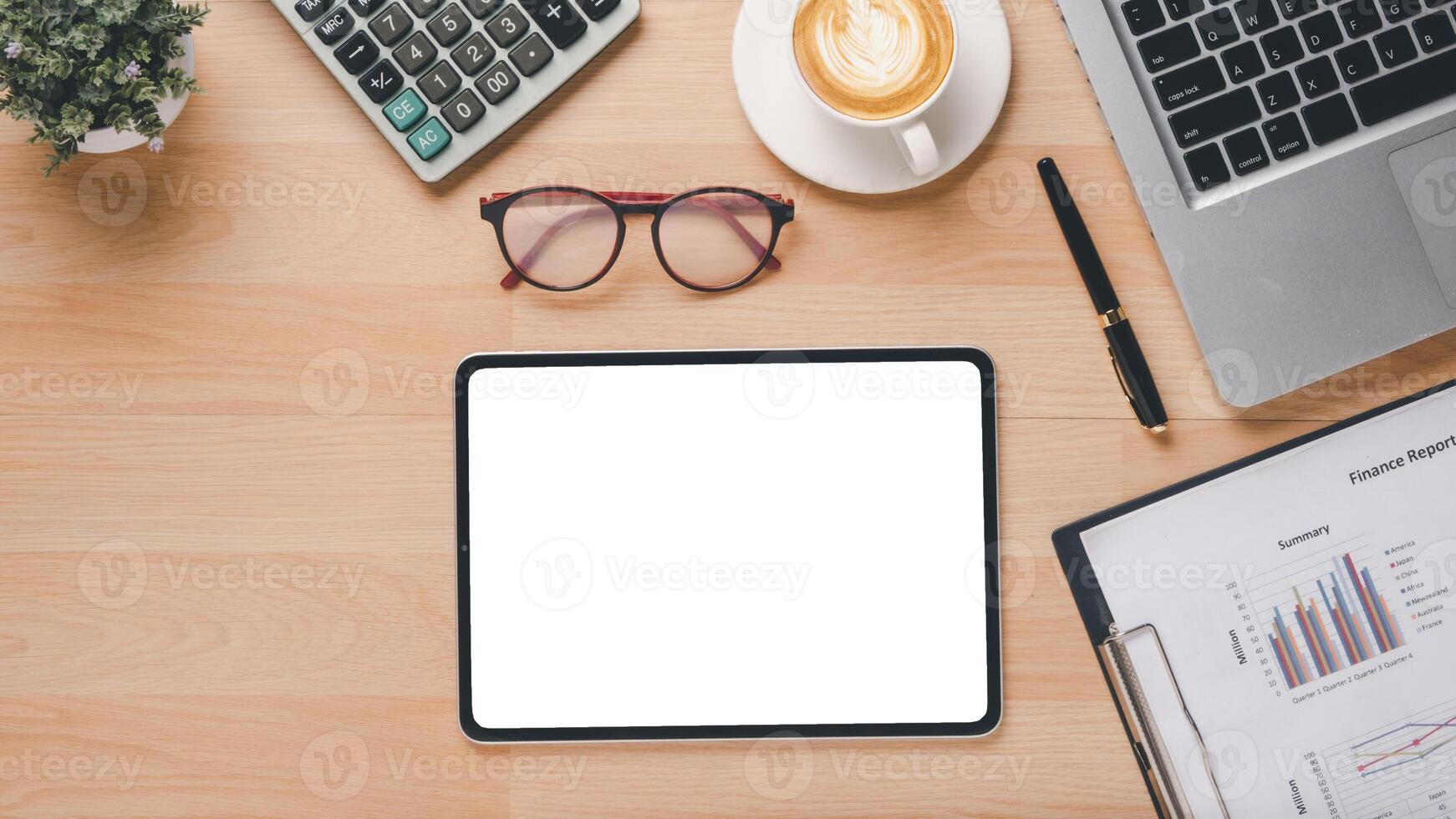 Haut vue de une professionnel espace de travail avec une tablette avec une Vide filtrer, ordinateur portable, financier rapports, calculatrice, et une tasse de café. photo