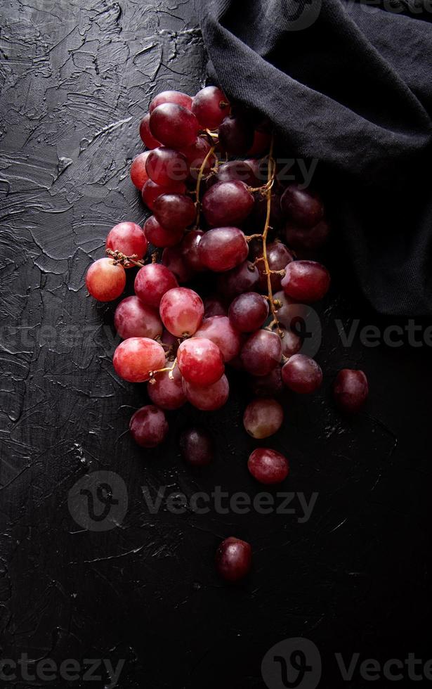 une grappe de raisins rouges vue de dessus sur fond sombre photo