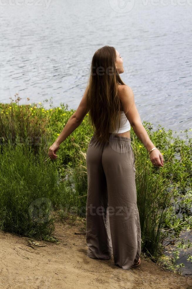caucasien adolescent femme permanent à rivière bord photo