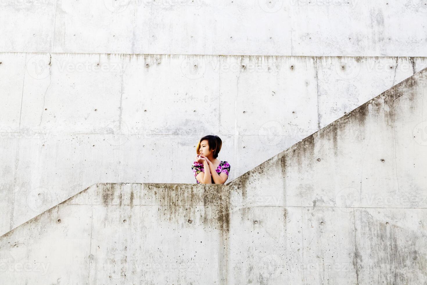 Jeune attrayant asiatique américain femme par ciment des murs photo