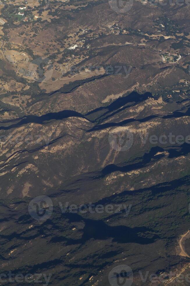 aérien image de collines avec certains habitations principalement vert des arbres photo