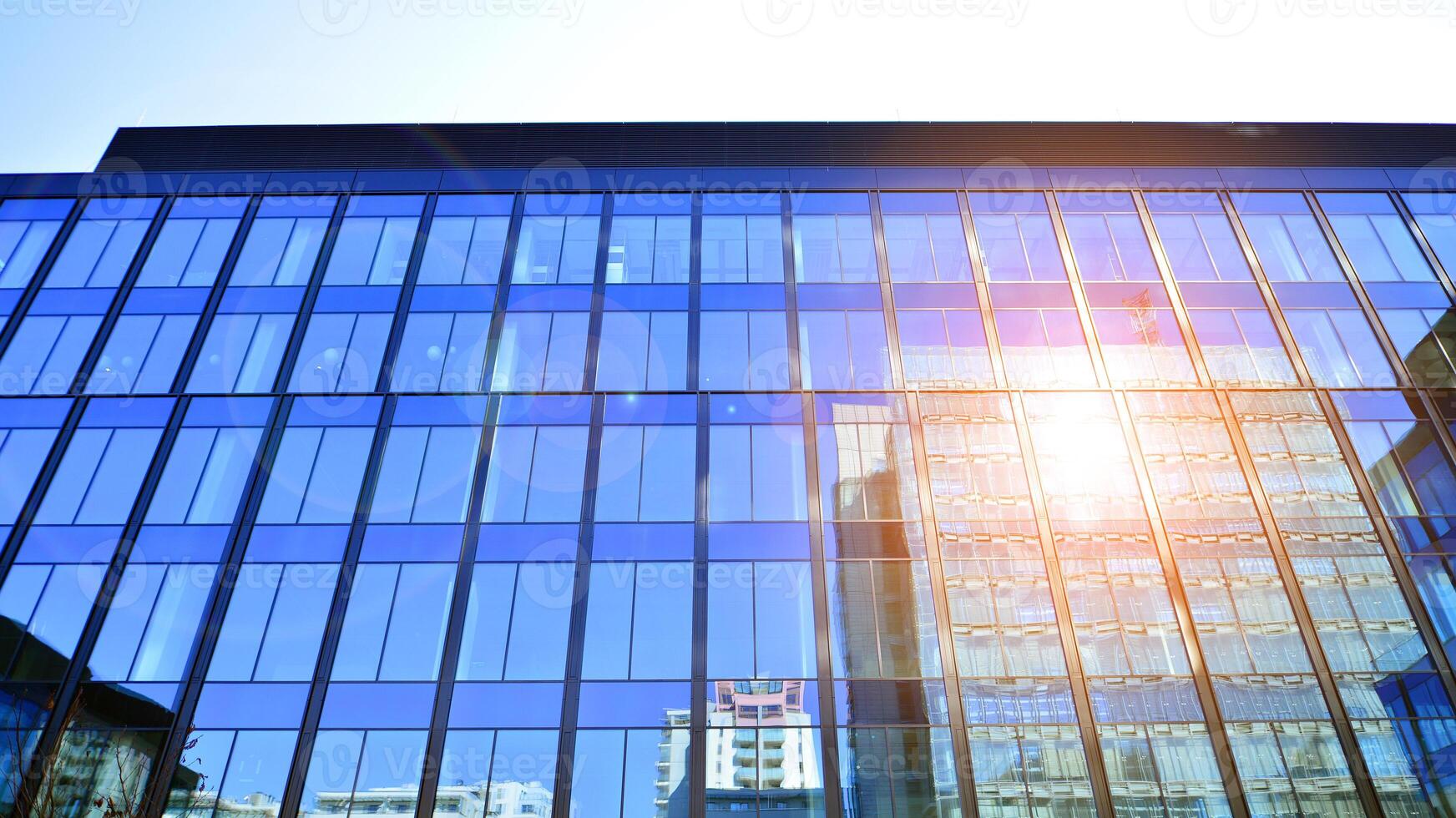 moderne Bureau bâtiment avec verre façade. transparent verre mur de Bureau bâtiment. réflexion de le bleu ciel sur le façade de le bâtiment. photo