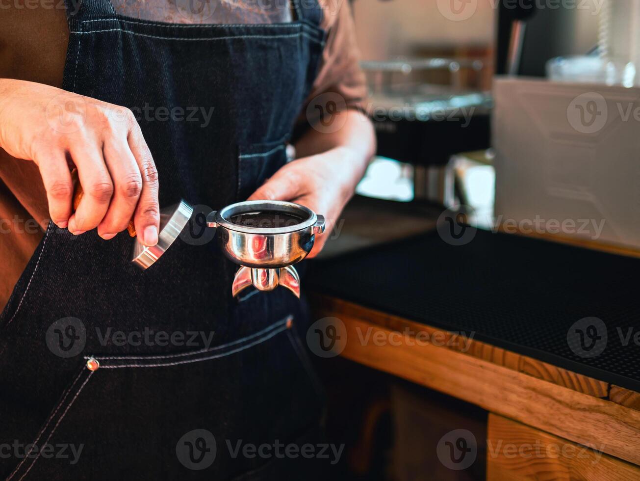 gros plan sur un café barista à la main faisant du café avec des presses manuelles du café moulu à l'aide d'un sabotage au café photo