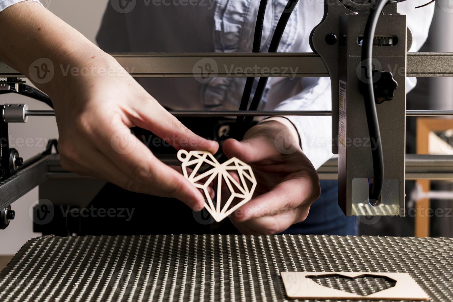 laser gravure et Coupe, femme en portant un exemple de une Couper en dehors en bois cœur photo