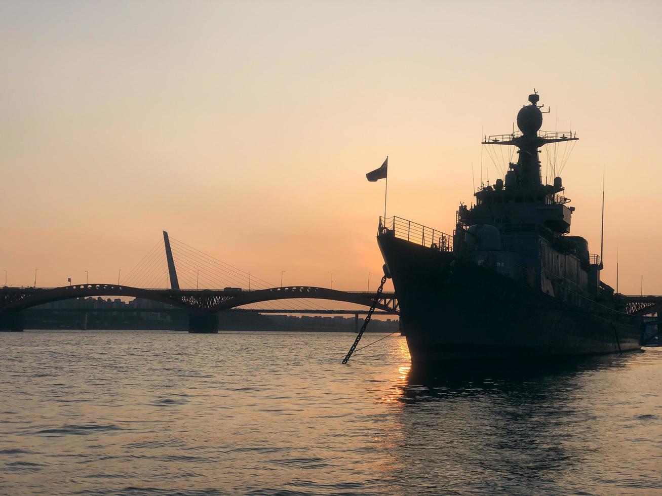 le coucher du soleil. silhouette d'un navire militaire à l'ancre photo