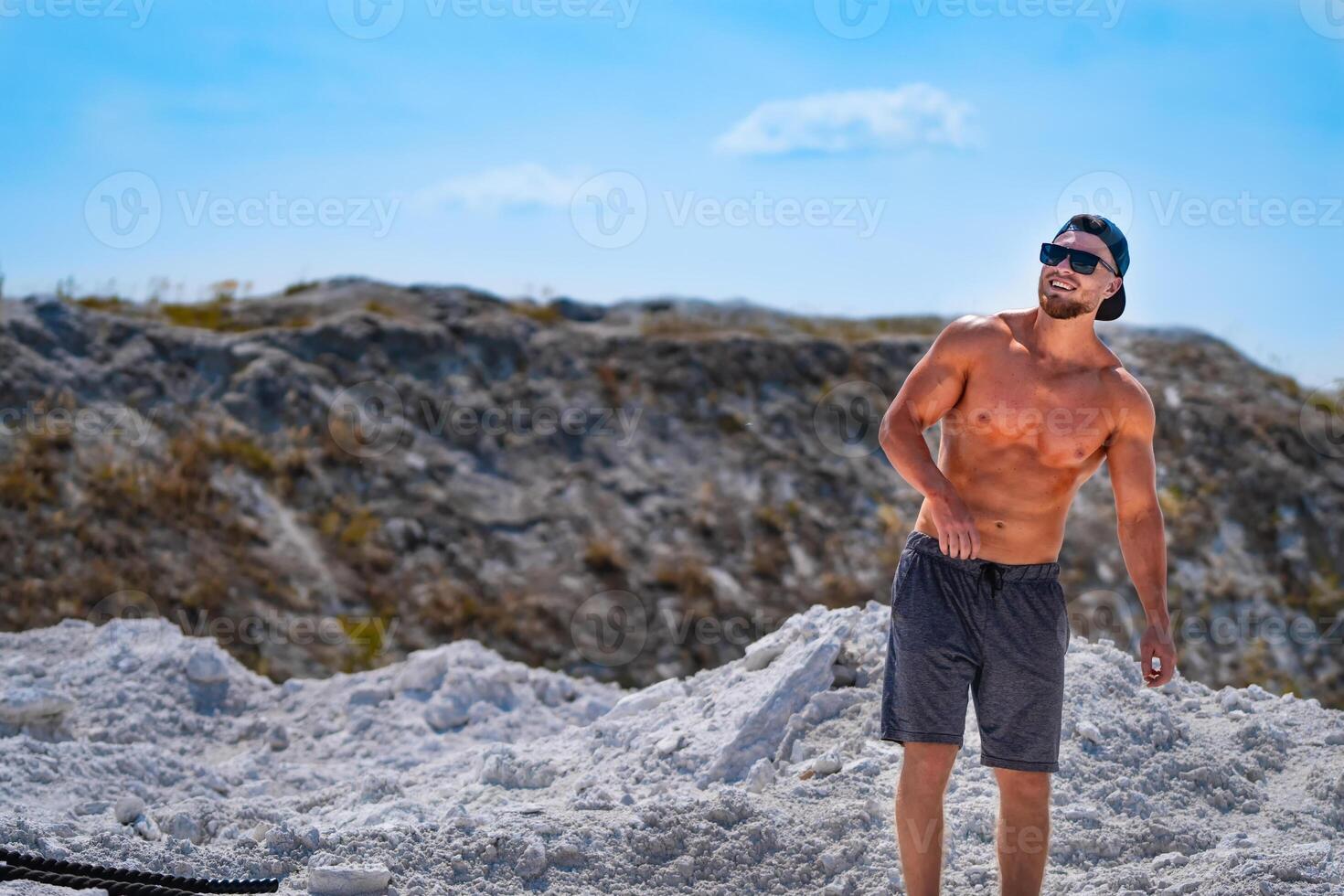 en forme élaboré homme en marchant en dehors avec bleu ciel. Beau musclé fort homme avec nu torse Extérieur. photo