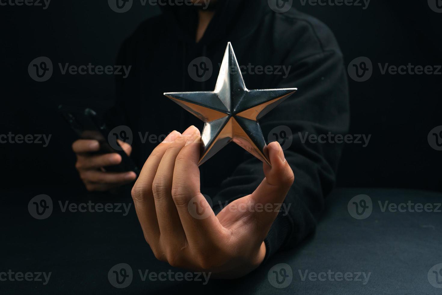 étoile d'or à portée de main sur fond sombre photo