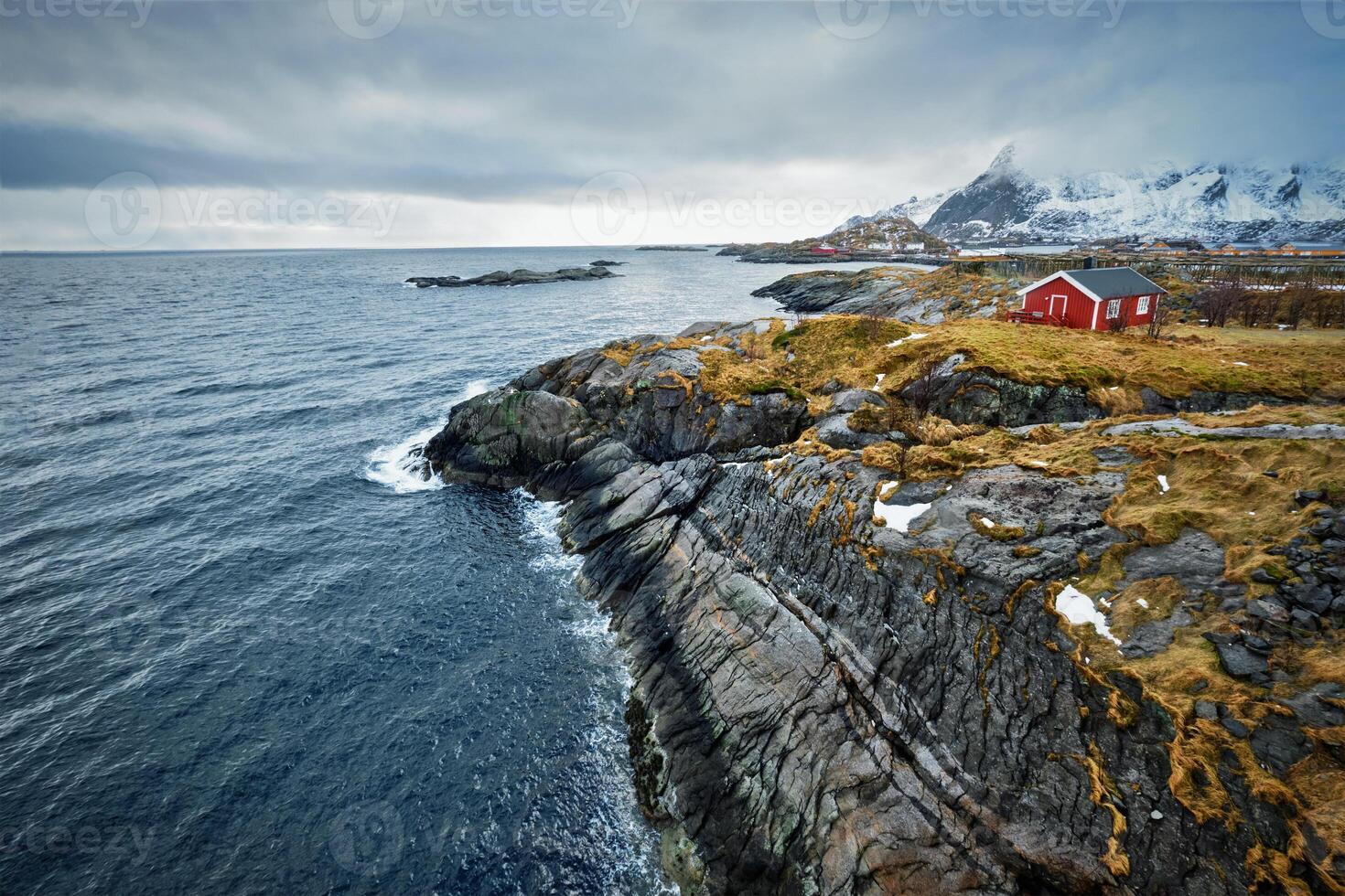 clif avec traditionnel rouge rorbu maison sur lofoten îles, Norvège photo