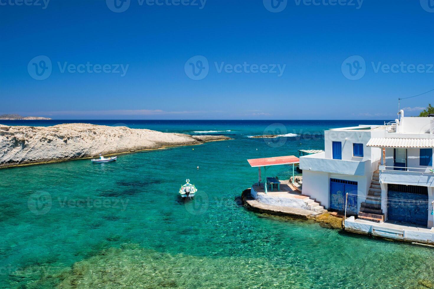 Grèce île milos. petit port avec pêche bateaux dans eau, blanchi à la chaux maison. mitakas village photo