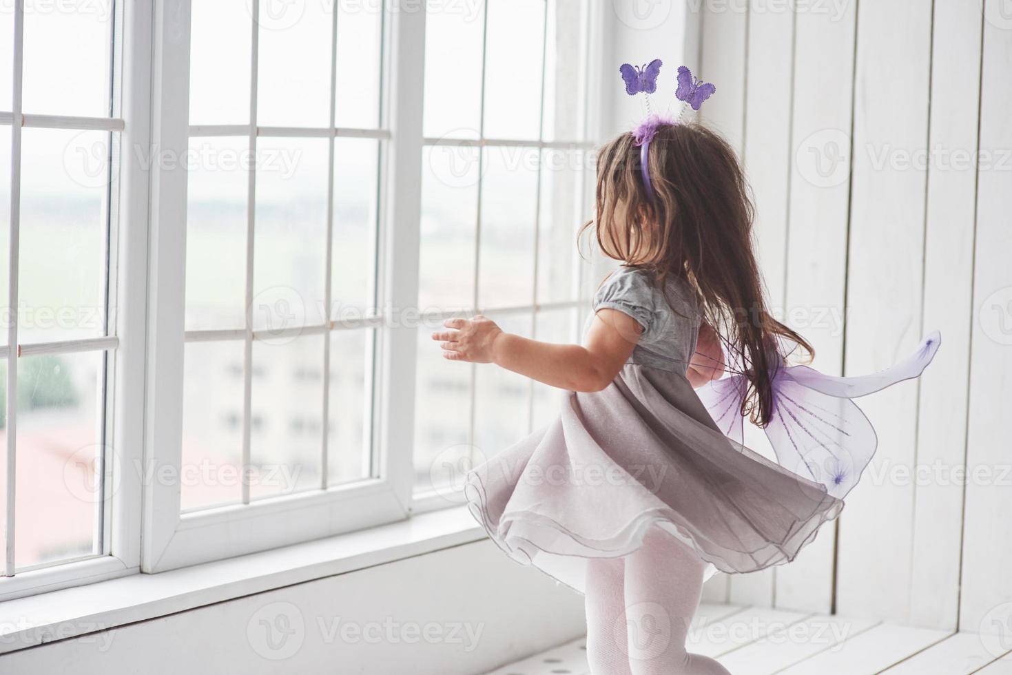 photo en mouvement. jolie petite fille dans le conte de fées s'habille en allant aux fenêtres pour regarder ce qu'il y a à l'extérieur