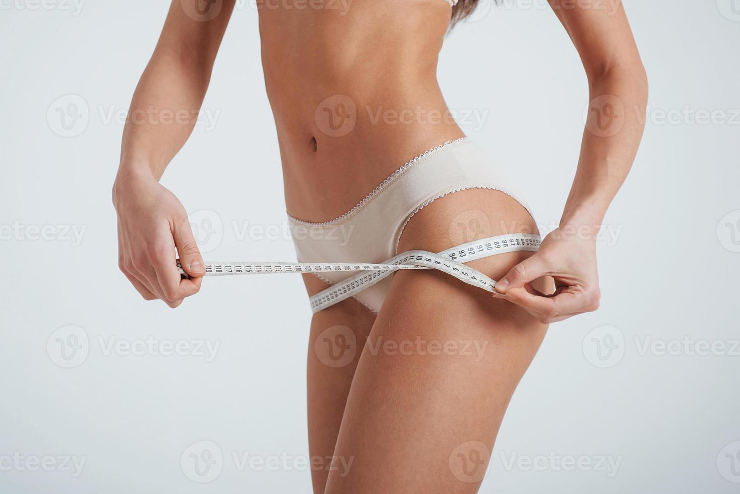 image recadrée d'une fille en sous-vêtements blancs mesurer les résultats de la remise en forme photo