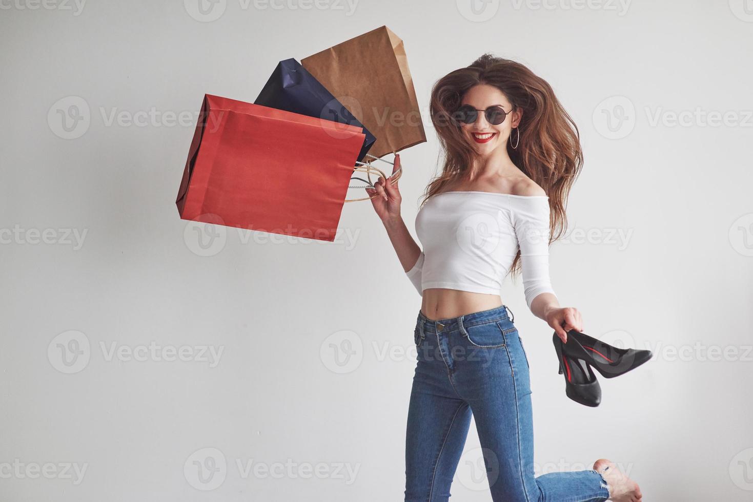 J'ai hâte d'essayer ces choses. juste du shopping. jeune femme élégante tenant les paquets avec des vêtements et des talons photo