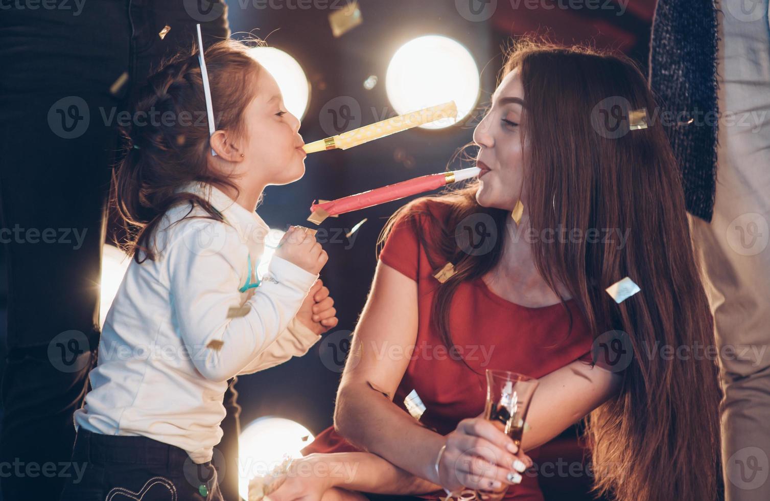 fille et mère s'amusant pendant la célébration du nouvel an en compagnie d'amis photo