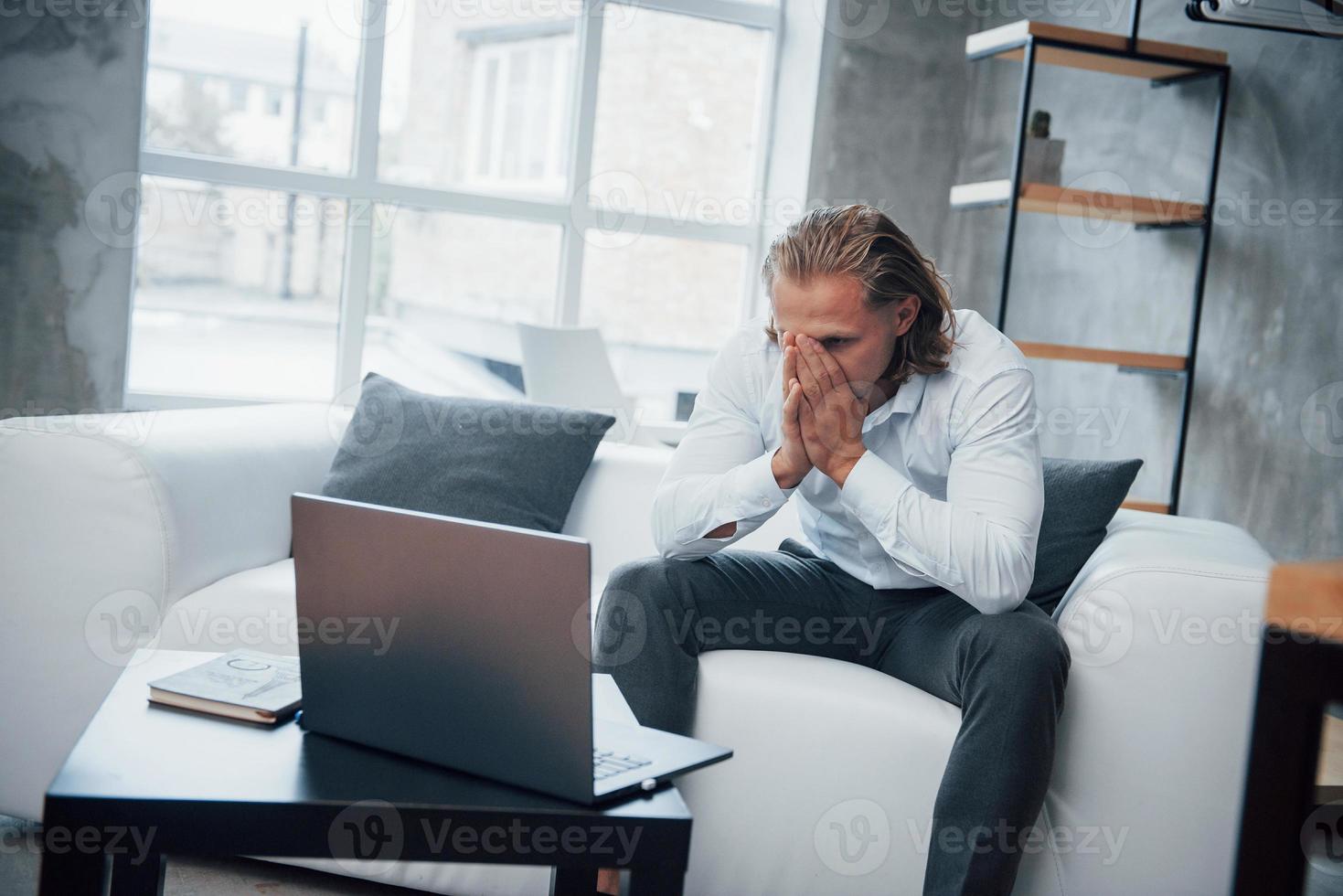 regarder l'échec. photo d'un jeune homme d'affaires assis sur un entraîneur et stressé au travail