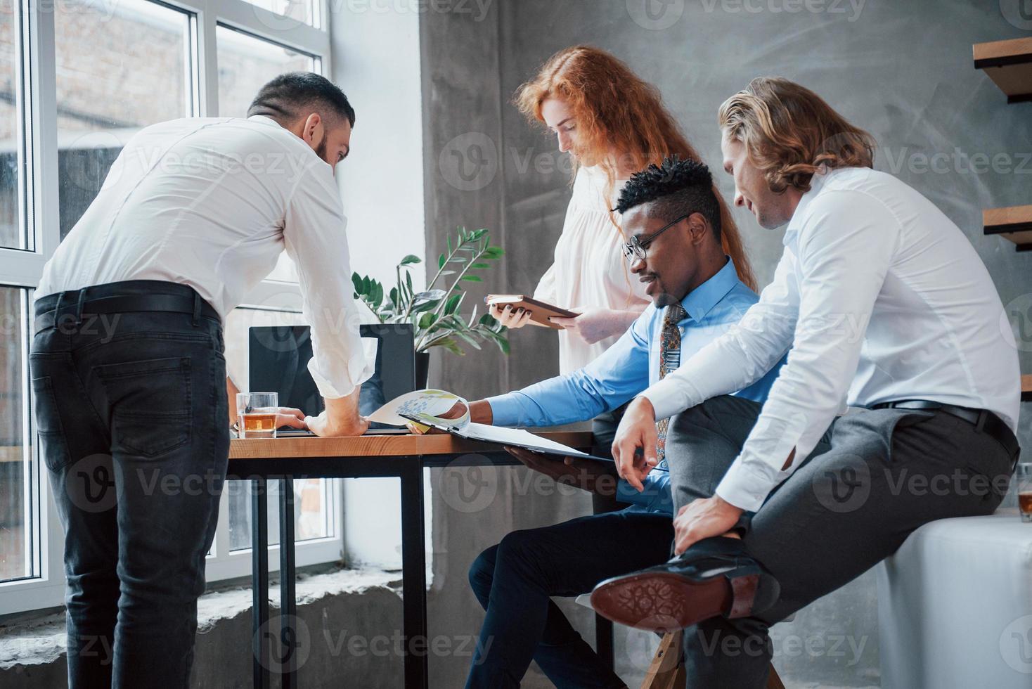 discuter du projet. groupe d'employés de bureau multiraciaux en vêtements formels parlant de tâches et de plans photo