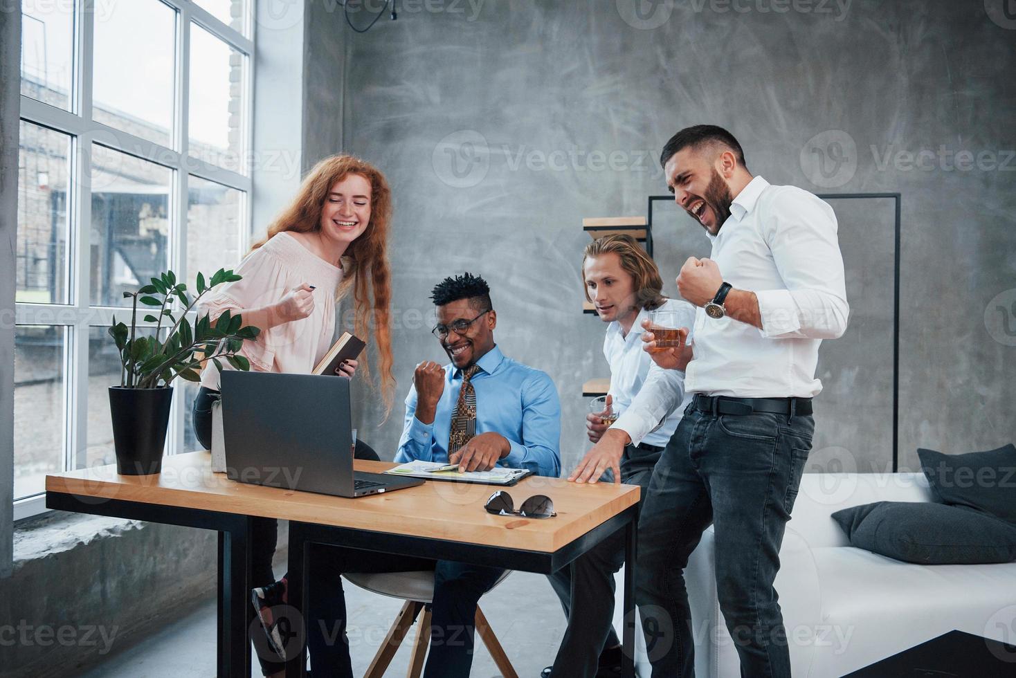 voilà à quoi ressemble le succès. groupe d'employés de bureau multiraciaux en vêtements formels parlant de tâches et de plans photo