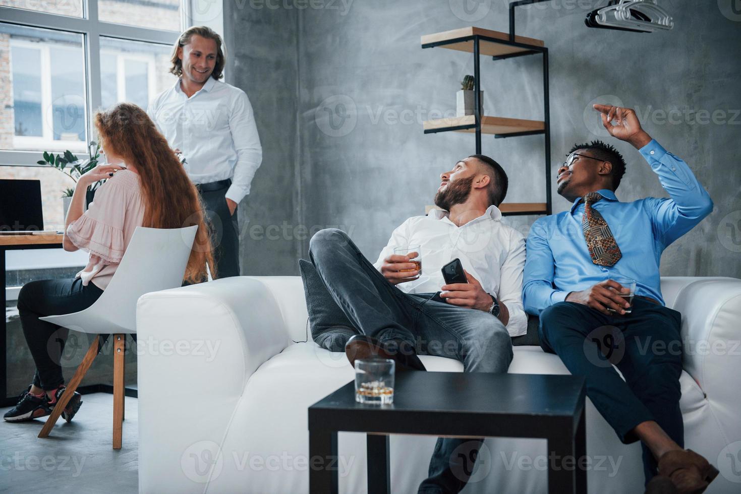 bel endroit ou travailler. groupe d'employés de bureau multiraciaux en vêtements formels parlant de tâches et de plans photo