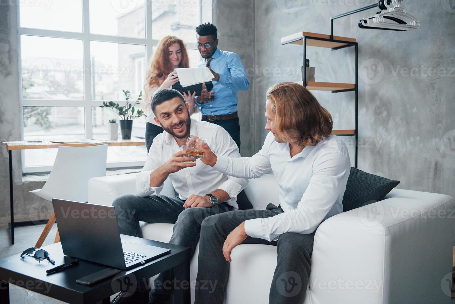 tourné pour l'entreprise. groupe d'employés de bureau multiraciaux en vêtements formels parlant de tâches et de plans photo