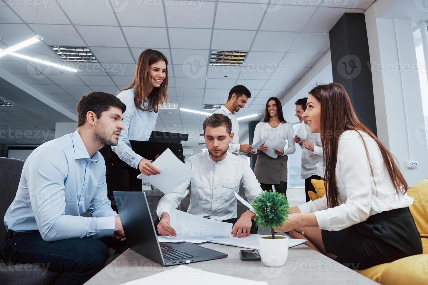 l'unité des gens pour le bien d'une grande idées. groupe de jeunes pigistes au bureau ont une conversation et sourient photo