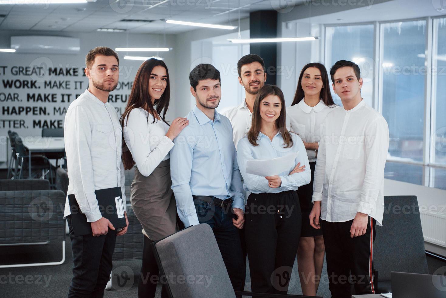 portrait de jeune équipe en vêtements classiques dans le bureau moderne bien éclairé photo