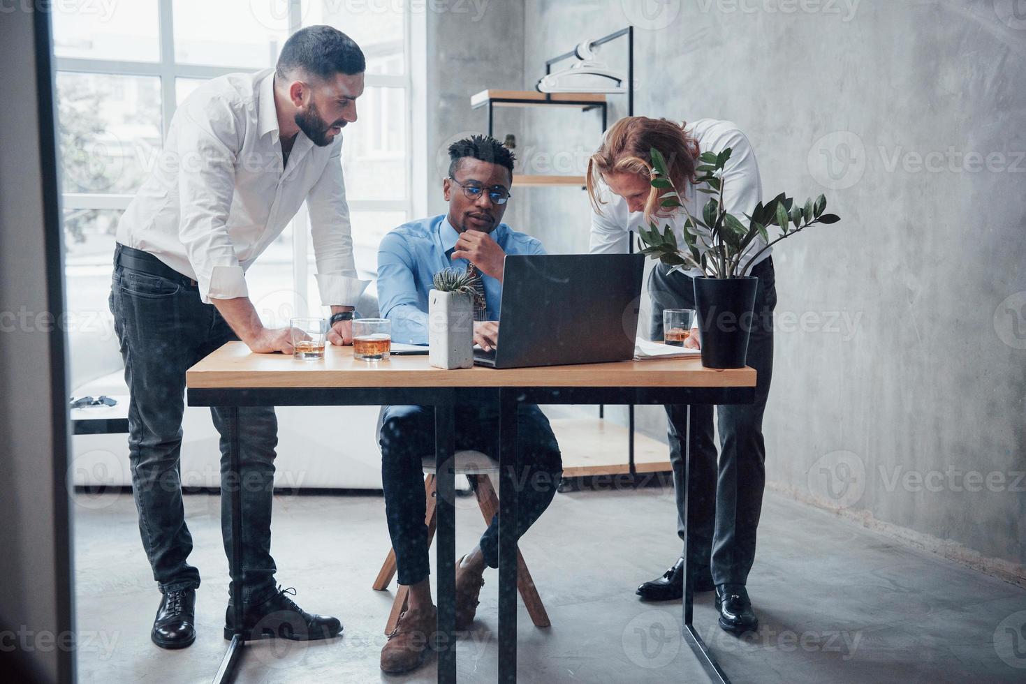 les travailleurs d'équipe font leur travail de routine au bureau avec fenêtre en arrière-plan photo