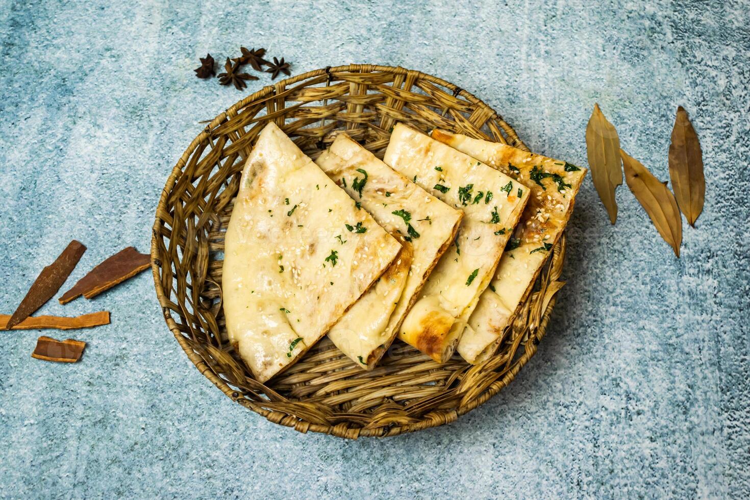 spécial Masala kulcha Naan servi dans une panier isolé sur gris Contexte Haut vue de bangladesh nourriture photo