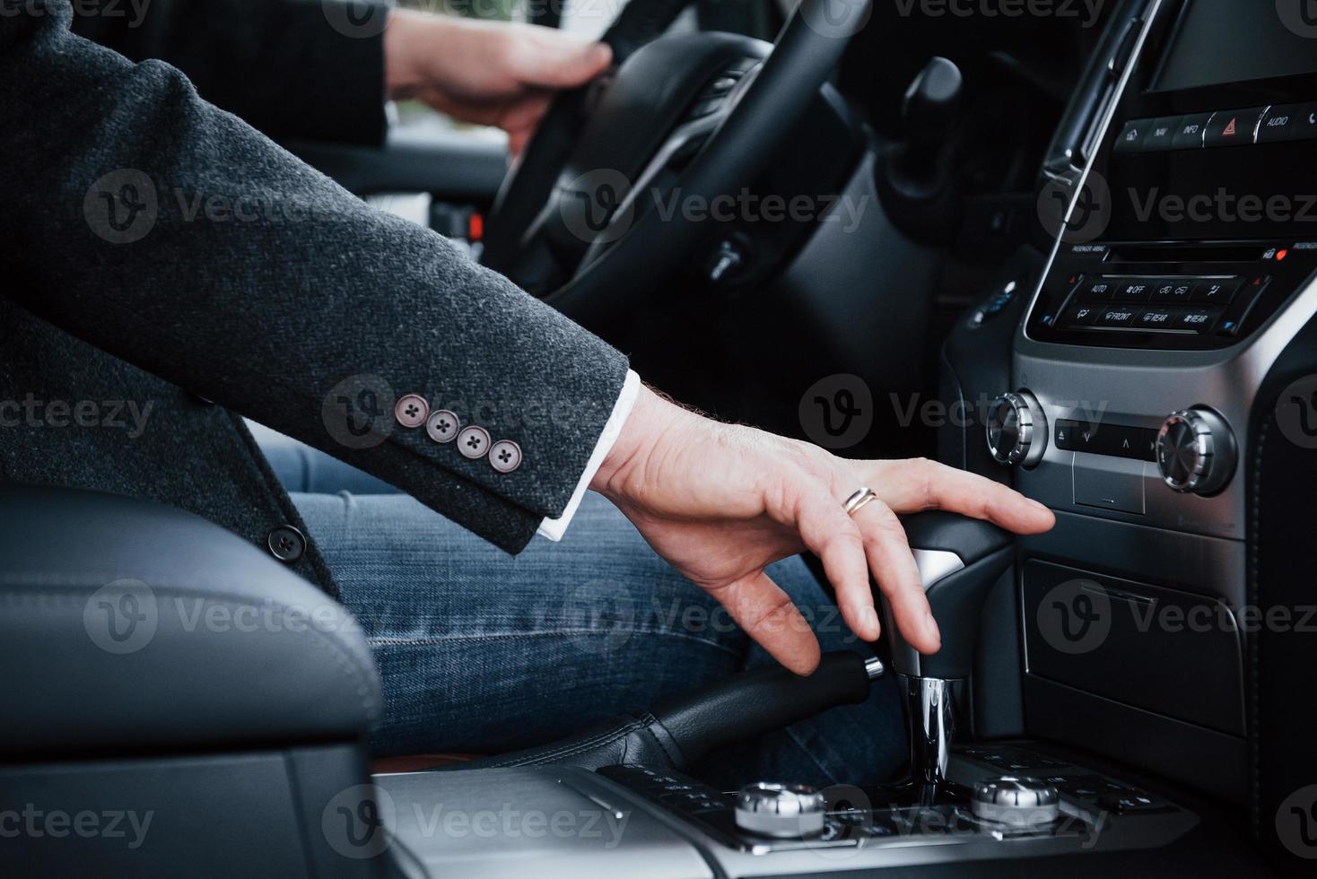 Vue rapprochée d'une personne adulte change de vitesse dans la nouvelle voiture de luxe photo