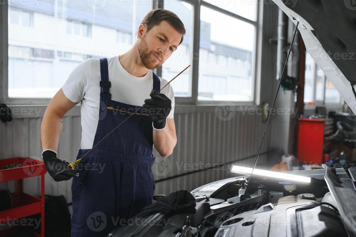 auto mécanicien vérification le pétrole niveau dans voiture moteur, inspecte moteur l'eau niveau jauge,concept de vérification le moteur pétrole niveau chaque temps avant sortie. photo