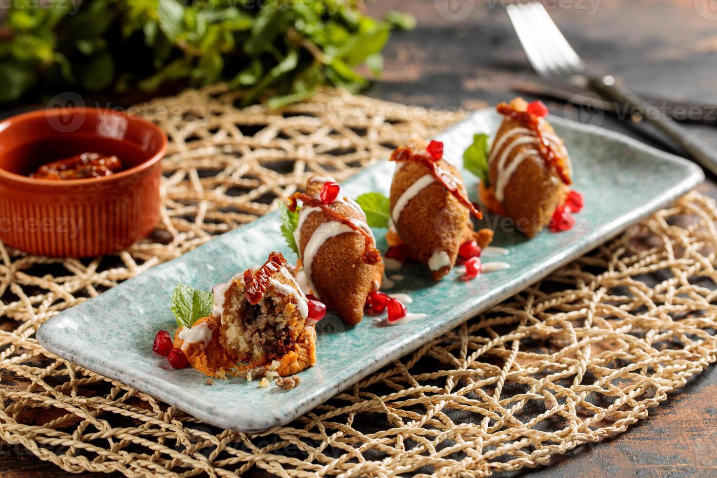 kibbeh ou kibe, quibe, kibbe avec mayo plonger, Chili sauce et Grenade des graines servi dans plat isolé sur table Haut vue de arabe petit déjeuner photo