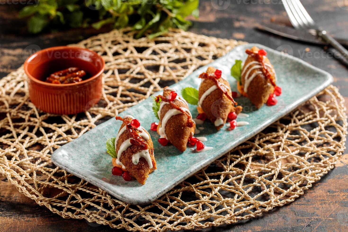 kibbeh ou kibe, quibe, kibbe avec mayo plonger, Chili sauce et Grenade des graines servi dans plat isolé sur table Haut vue de arabe petit déjeuner photo