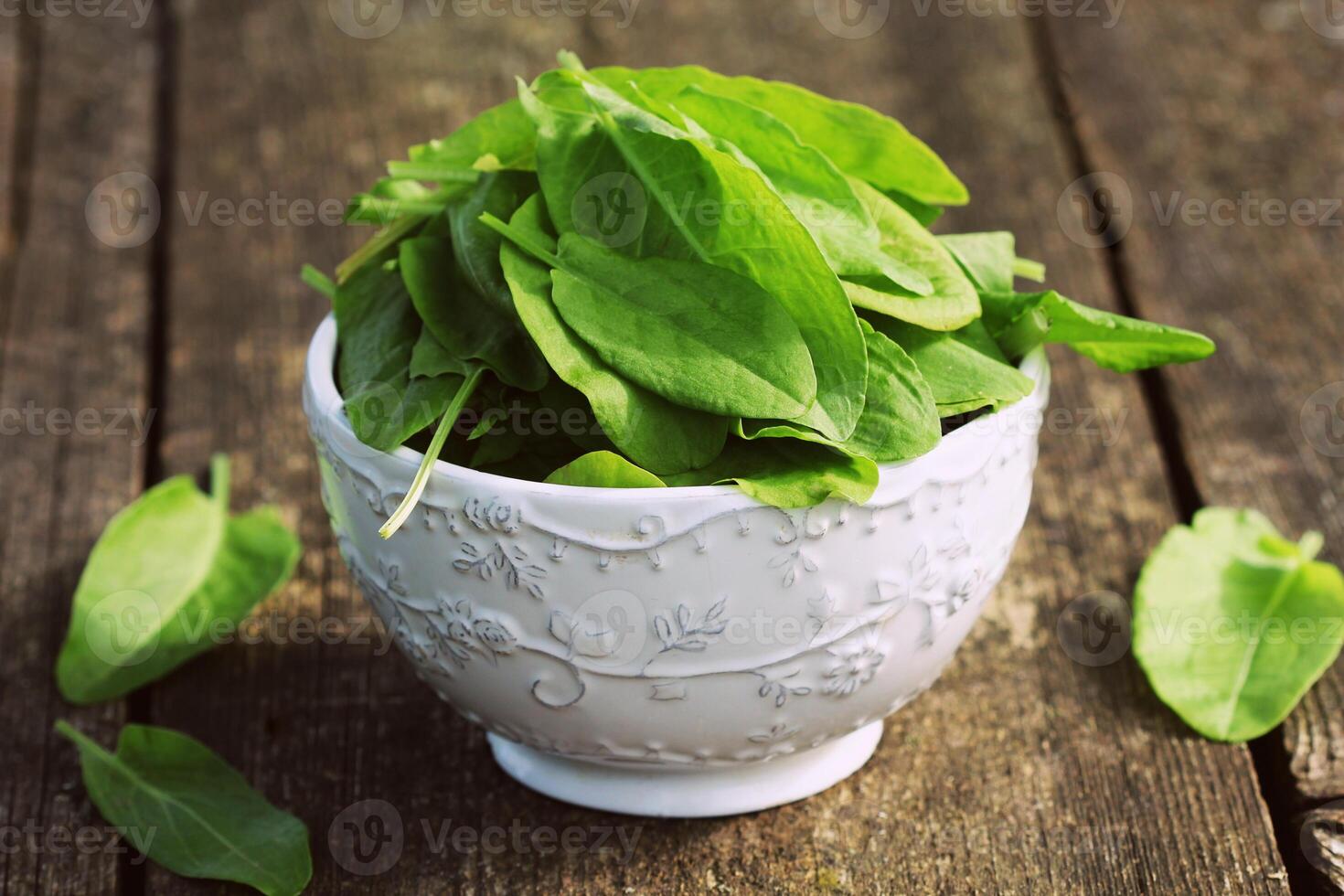 Frais biologique oseille feuilles dans bol sur en bois table photo