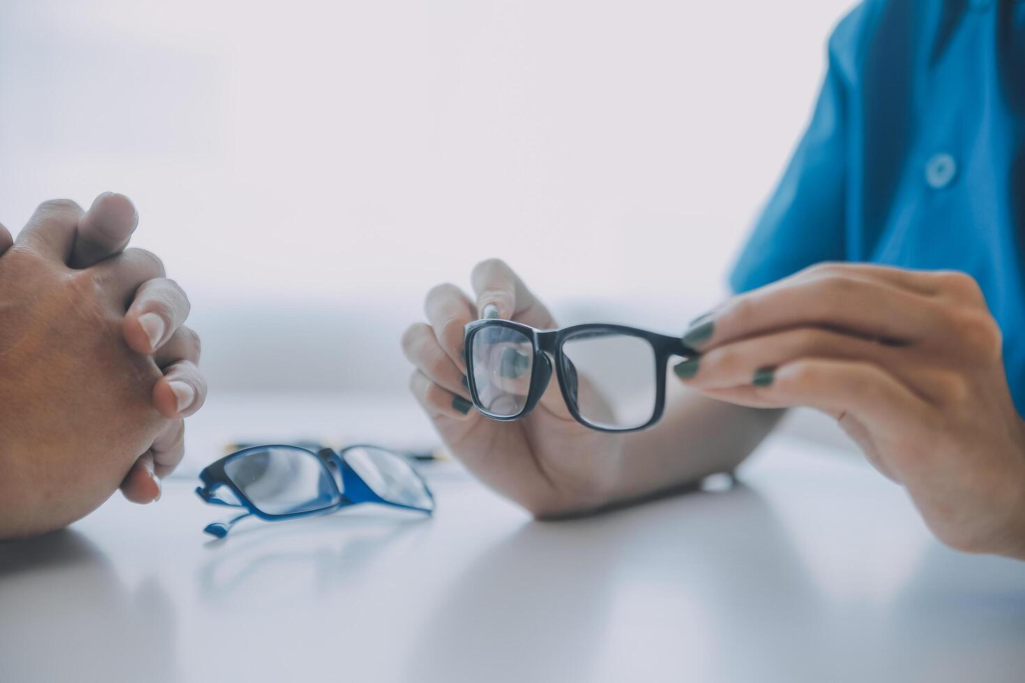 fermer de asiatique femelle médecin parlant avec personnes âgées patient montrant globe oculaire modèle et expliquant œil maladie dans hôpital photo