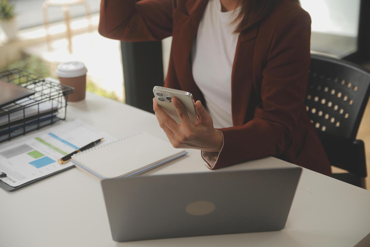 coup de une asiatique Jeune affaires femelle travail sur portable dans sa poste de travail. photo