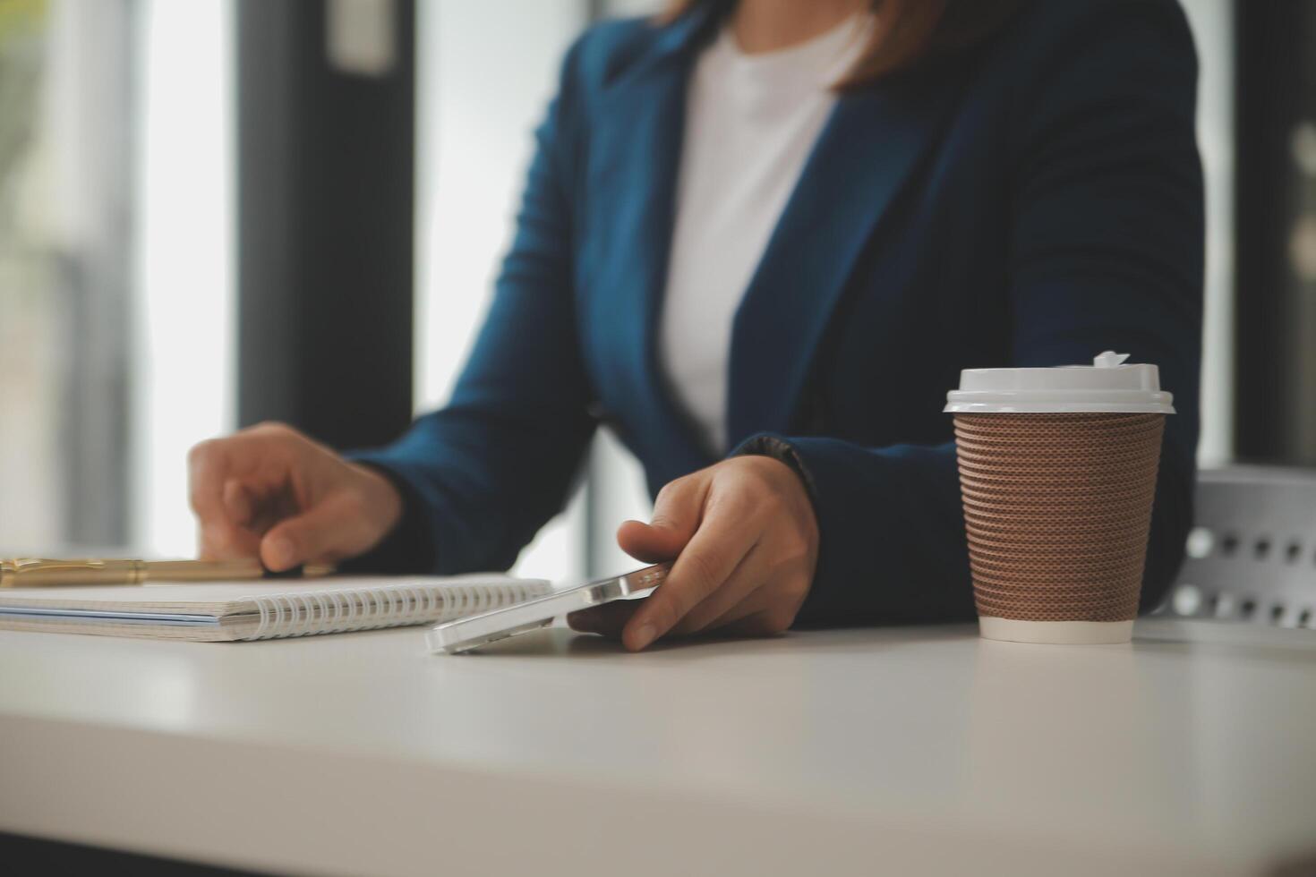 coup de une asiatique Jeune affaires femelle travail sur portable dans sa poste de travail. photo