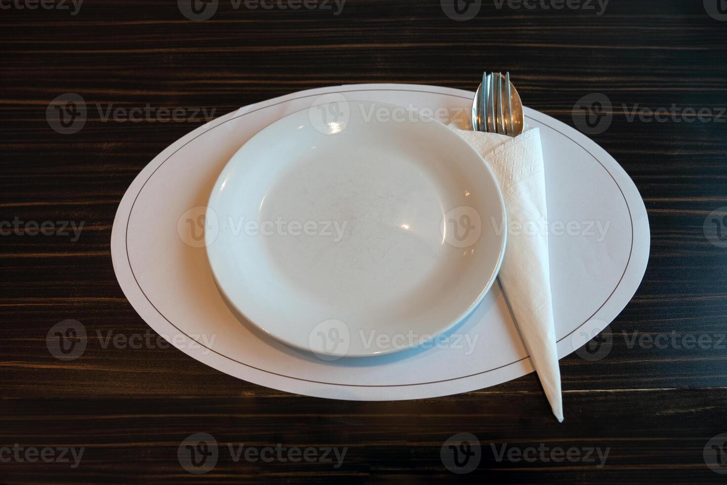 blanc céramique plat avec cuillère fourchette et serviette de table sur en bois table photo