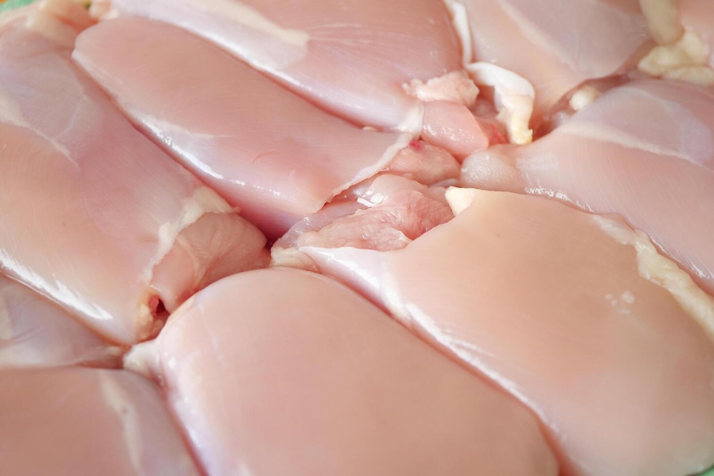 Viande crue de poitrine de poulet sur une assiette sur fond blanc photo