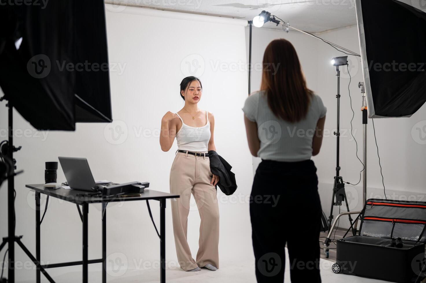 une professionnel photographe est prise des photos de un attrayant Jeune asiatique femelle modèle dans une studio
