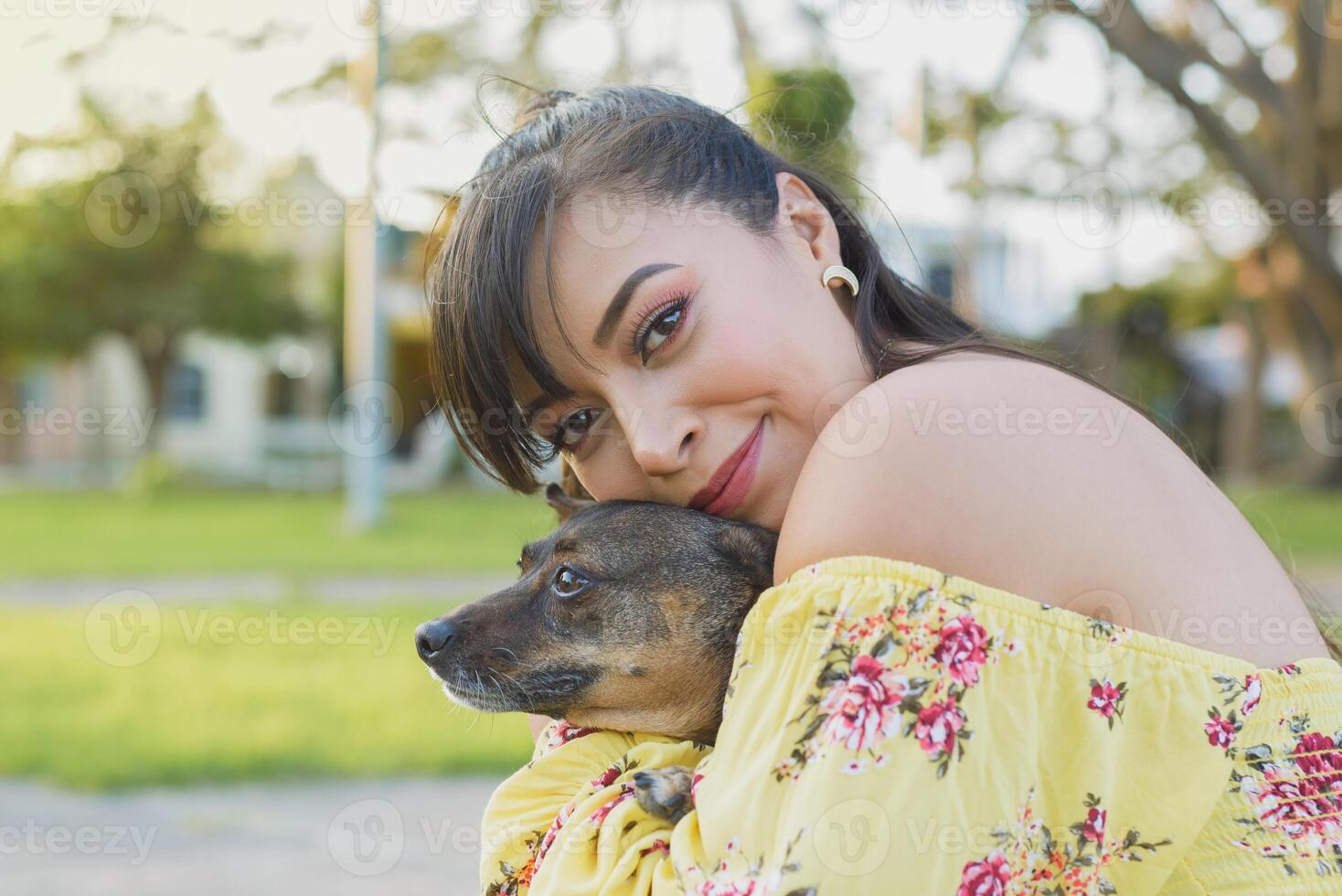 femme étreindre sa animal de compagnie dans une Publique jardin à le coucher du soleil. chien amoureux. photo