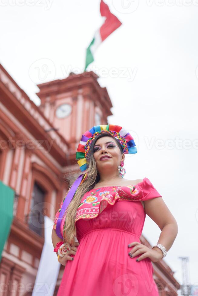 mexicain femme portant traditionnel robe. rue décoré avec couleurs de le mexicain drapeau. cinco de mayo fête. photo